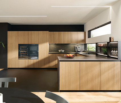 Next125 bei Himmlisch Wohnen Moderne Holzküche mit Kücheninsel, dunkler Rückwand und großem Fenster