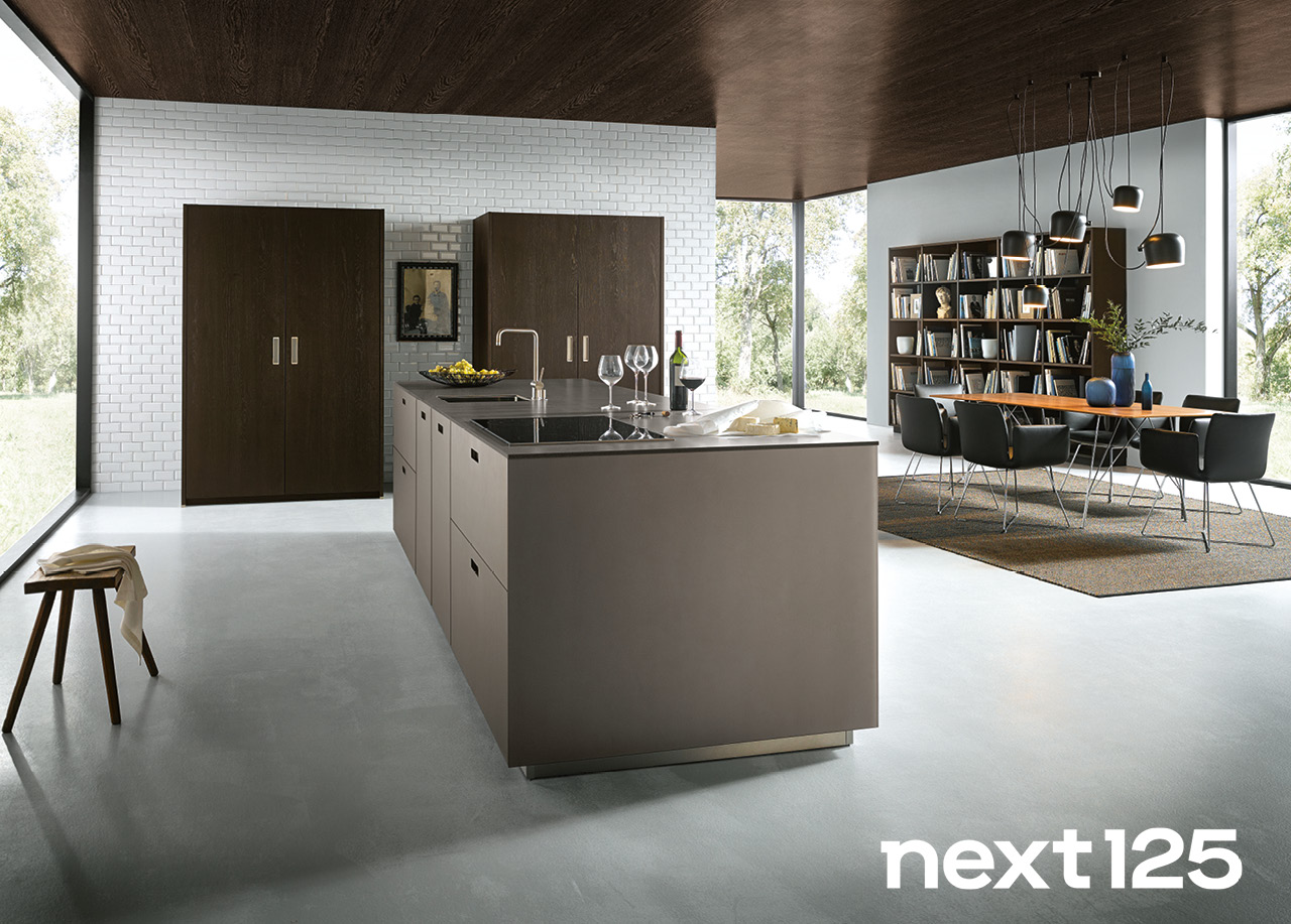 Next125 Küchen bei Himmlisch Wohnen Moderne Wohnküche mit Kücheninsel, Essbereich und bodentiefen Fenstern