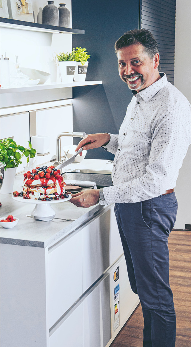 Küchen bei Himmlisch Wohnen Herr Franke mit Beerentorte in moderner Kueche