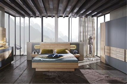 Modernes Schlafzimmer mit Holzbett, Kleiderschrank und Panoramafenstern mit Bergblick.