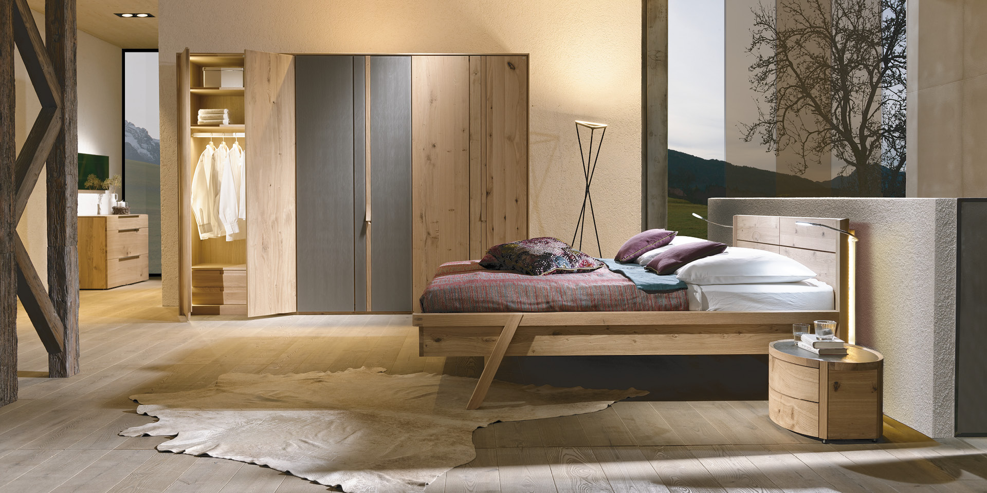 Holz-Schlafzimmer mit Bett, Nachttisch und großem Kleiderschrank.
