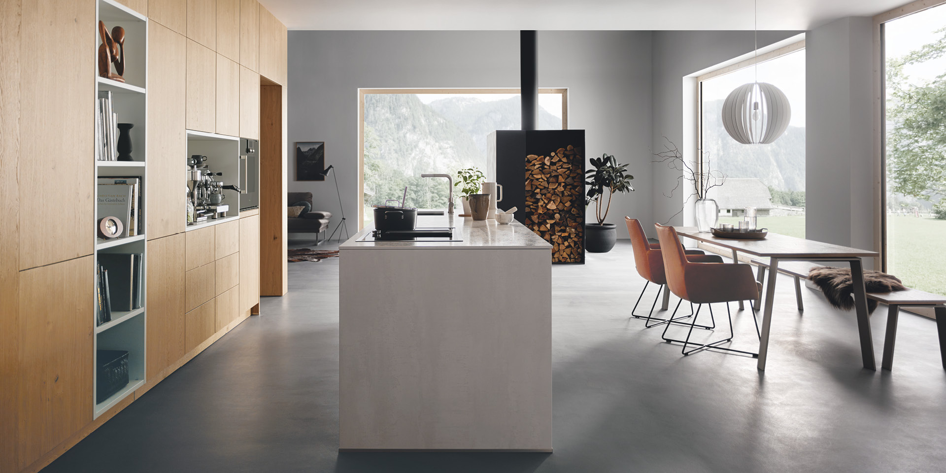 Offene Küche mit Holzfronten, Kochinsel und Essbereich mit Bergblick.