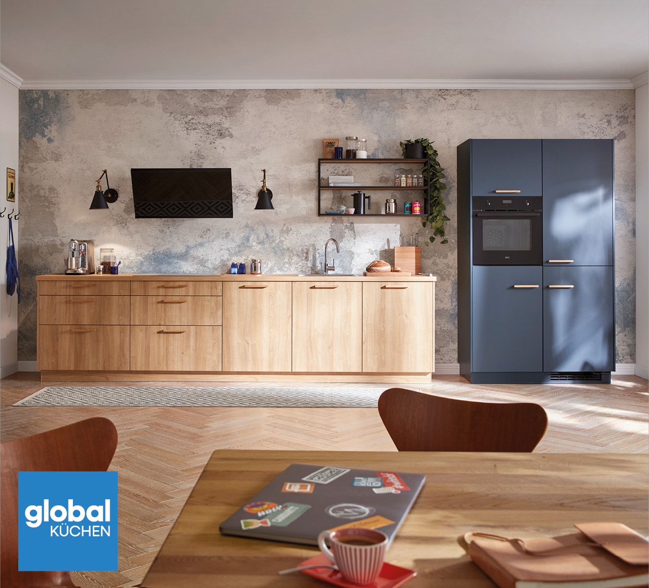 Offene Küche mit Holzzeile, blauem Hochschrank, Dunstabzug und Esstisch