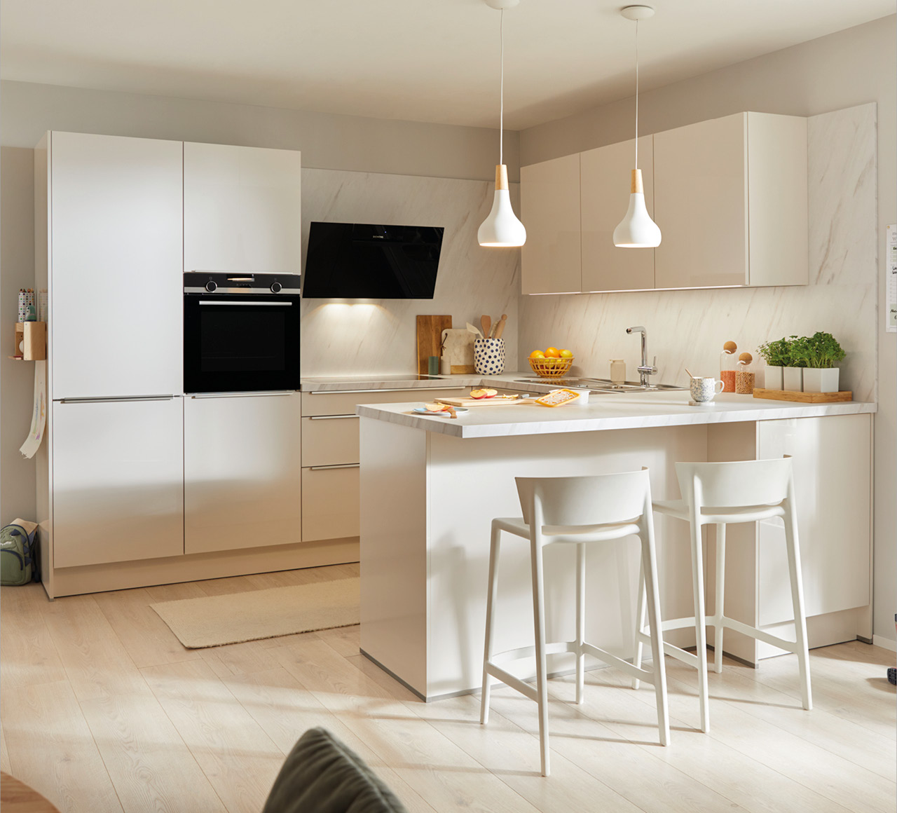 Helle Wohnküche mit Kochinsel, Barhockern, Einbaugeräten und Pendelleuchten