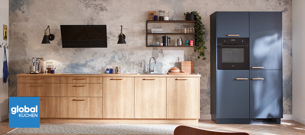 Offene Küche mit Holzzeile, blauem Hochschrank, Dunstabzug und Esstisch