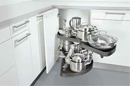 Eckschrankauszug mit Töpfen und Deckeln in weißer Einbauküche