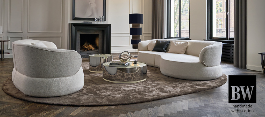Wohnzimmer mit weißem Sofa, Couchtischen und Kamin, Logo BW
