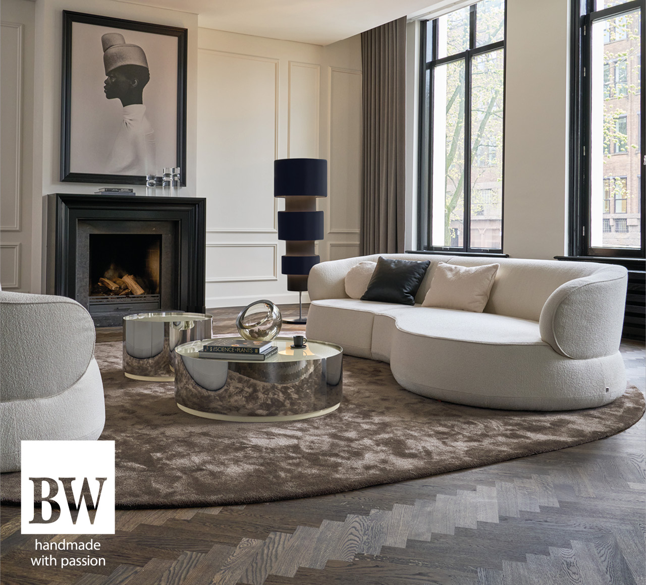 Wohnzimmer mit weißem Sofa, Couchtischen und Kamin, Logo BW
