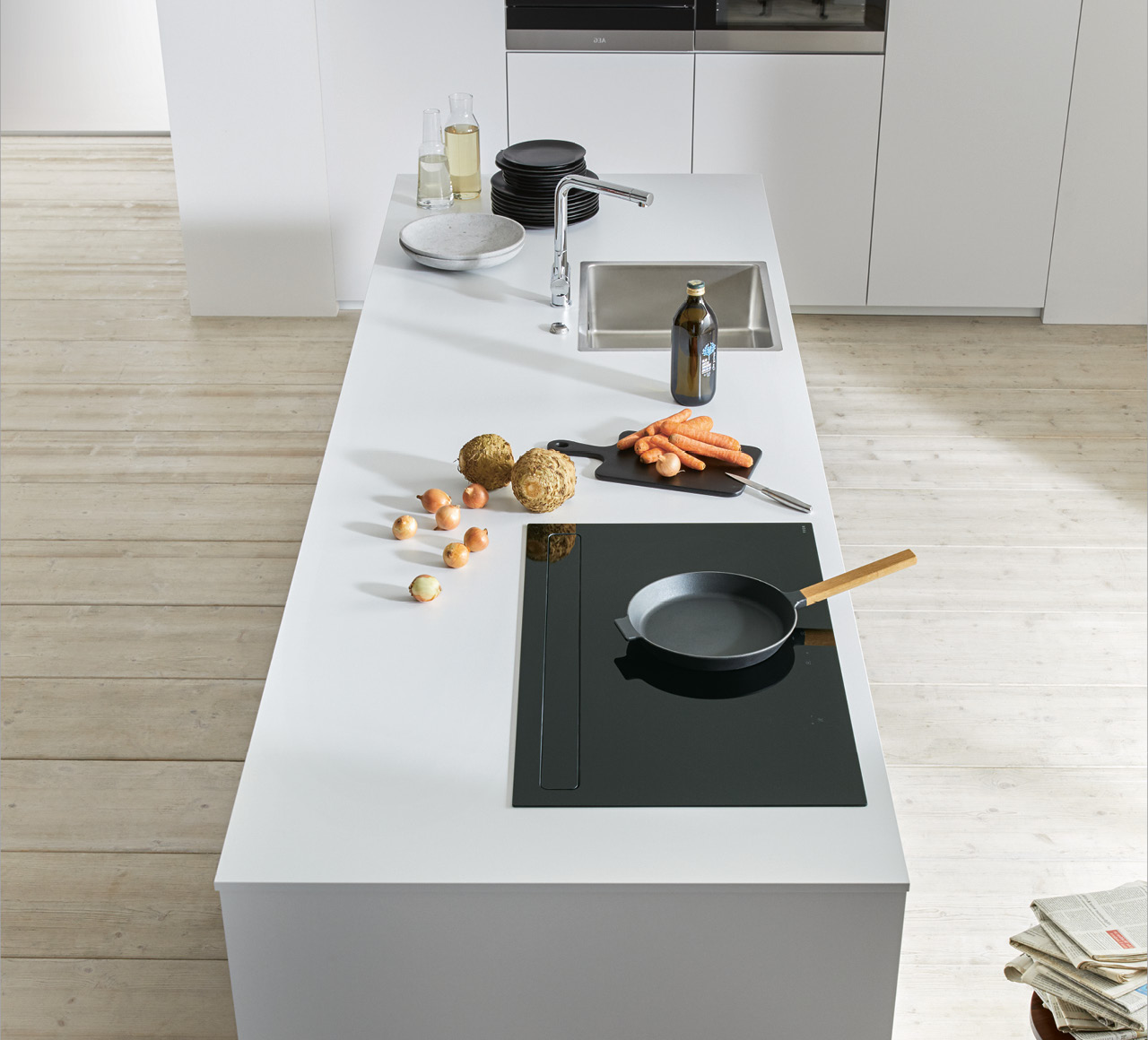 Weiße Küchenarbeitsplatte mit Spüle, Induktionskochfeld und Schneidebrett