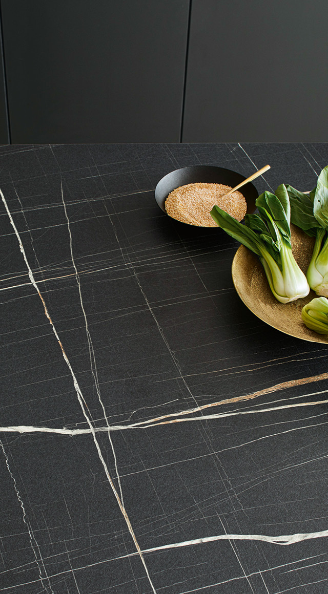 Dunkle Küchenarbeitsplatte in Steinoptik mit Schale und Gemüse