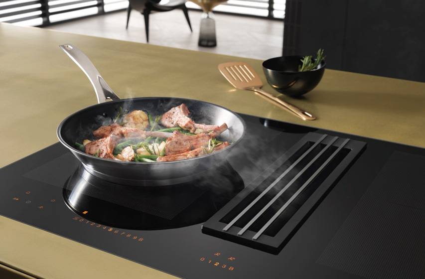 Kochfeldabzug neben Pfanne saugt Bratdampf direkt am Kochfeld ab