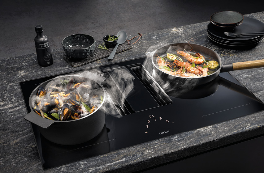 Kochfeldabzug saugt Kochdampf zwischen Topf und Pfanne ab