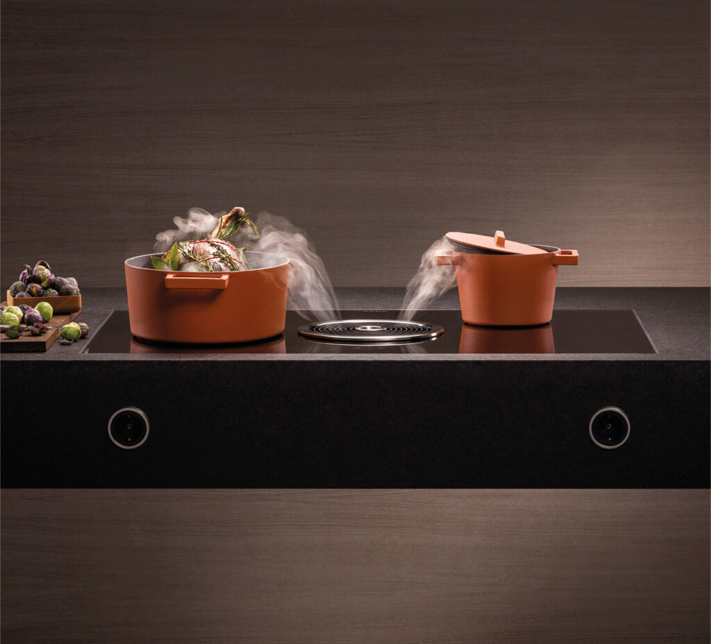 Kochfeldabzug saugt Dampf von zwei Töpfen auf Kücheninsel ab