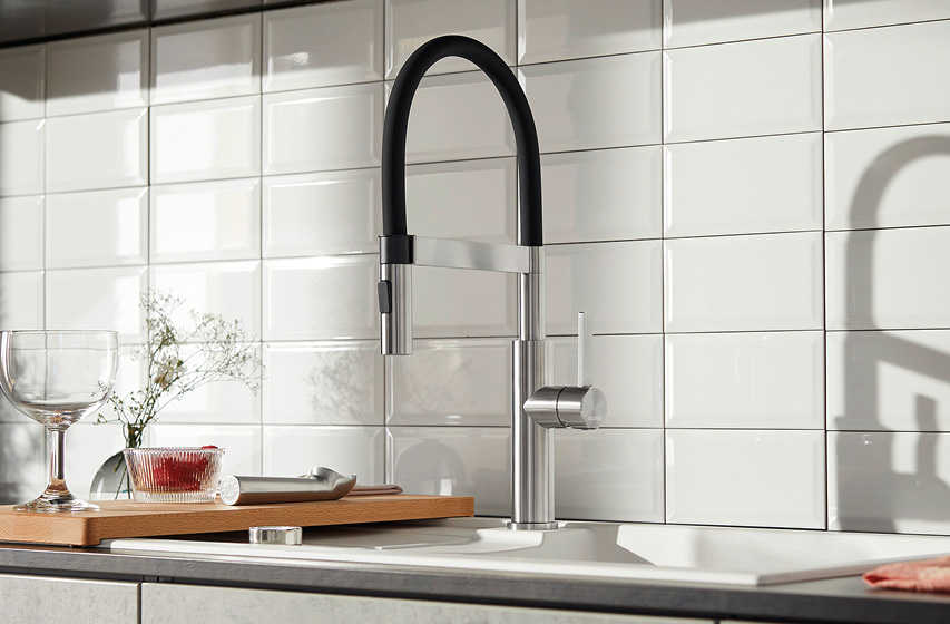 Moderne Küchenarmatur mit schwarzem Bogen über weißer Spüle