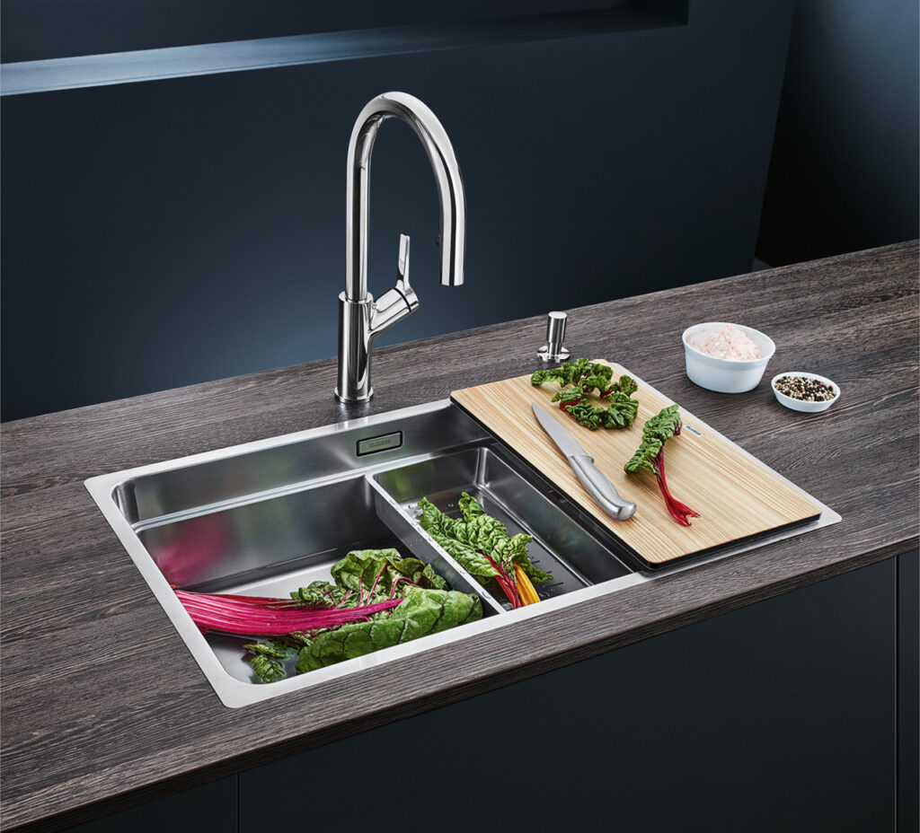 Edelstahlspüle mit hohem Chrom-Wasserhahn auf dunkler Küchenarbeitsplatte