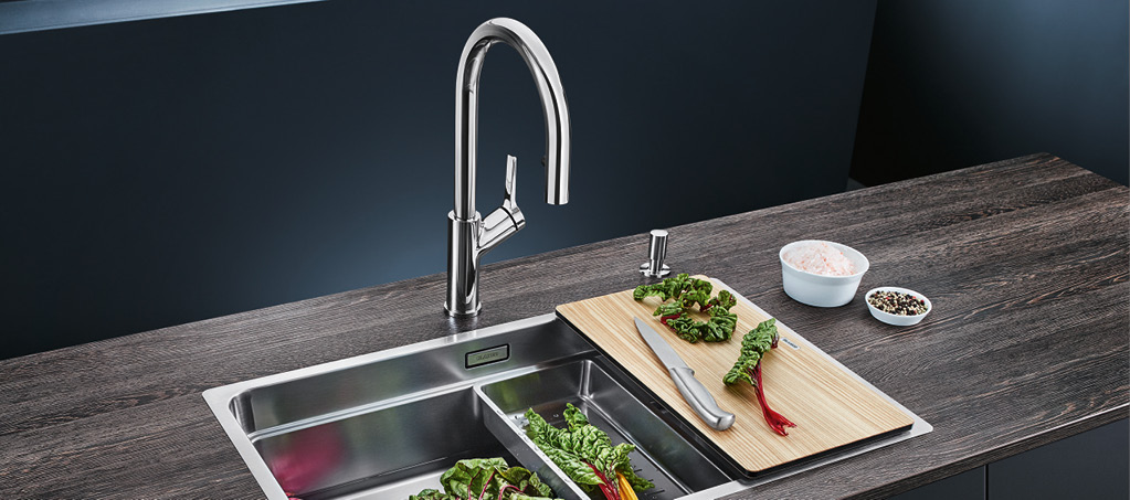 Edelstahlspüle mit hohem Chrom-Wasserhahn auf dunkler Küchenarbeitsplatte