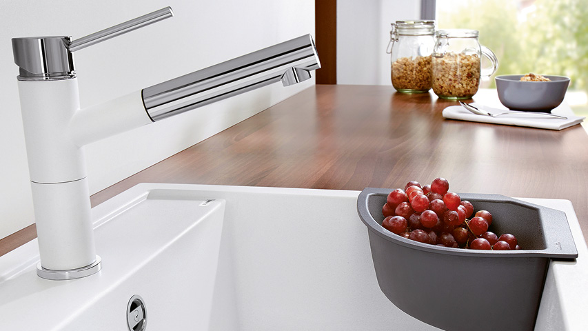 Wasserhahn mit ausziehbarer Brause über schwarzer Küchenspüle