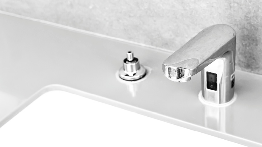 Nahaufnahme von Küchenwasserhahn am weißen Spülbecken