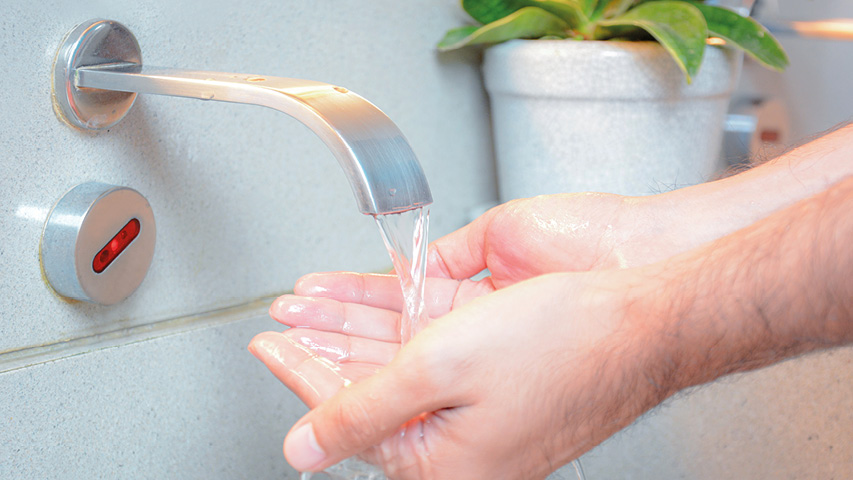 Hände unter fließendem Wasser am Küchenwasserhahn