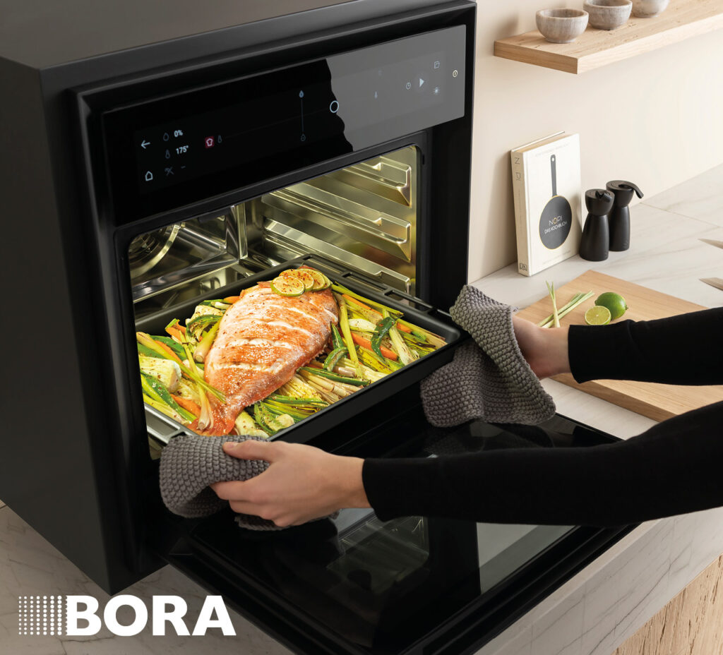 Dampfbackofen mit herausgezogenem Blech und gegartem Lachsgericht