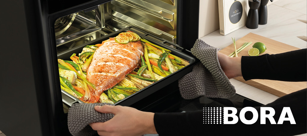 Dampfbackofen mit herausgezogenem Blech und gegartem Lachsgericht