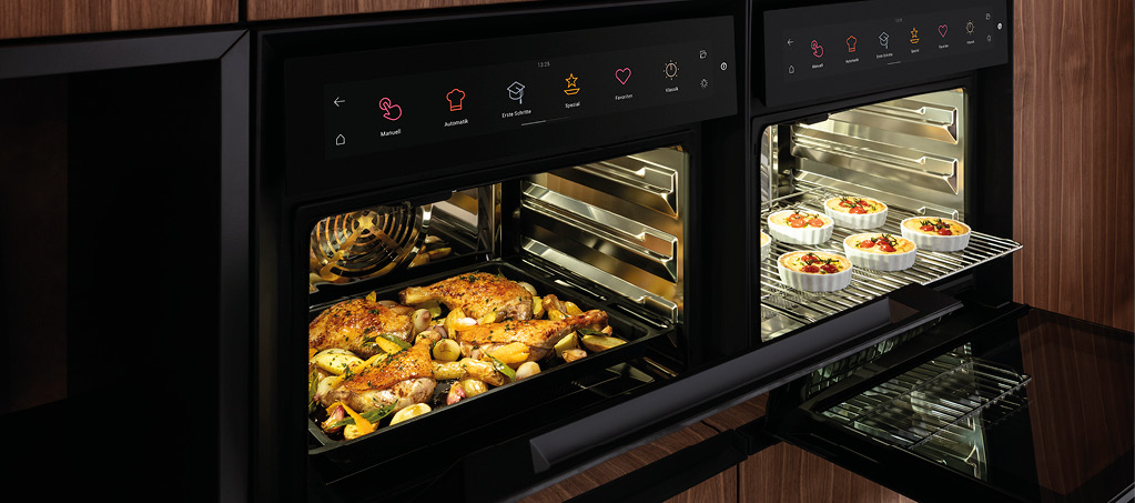 Zwei Dampfbacköfen mit geöffneten Türen und Speisen auf Blechen