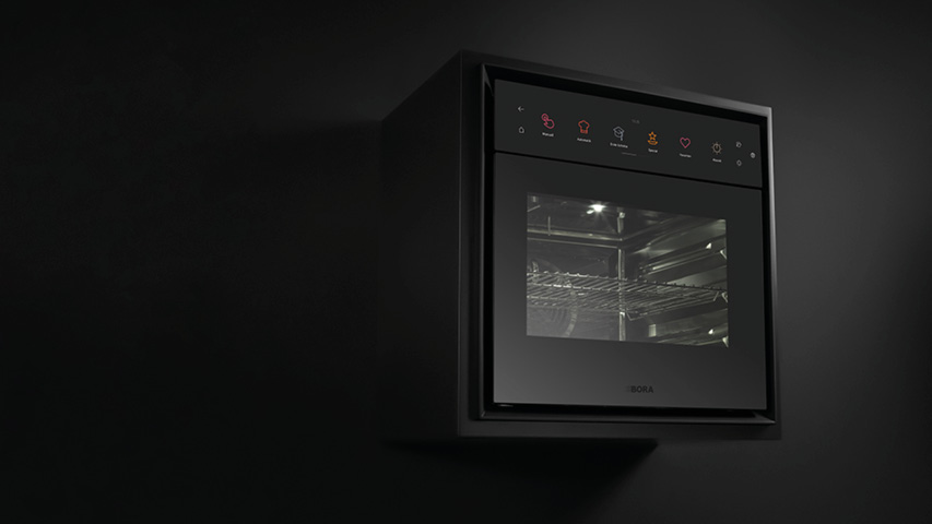 Schwarzer Dampfbackofen frontal vor dunklem Hintergrund in Einbauküche