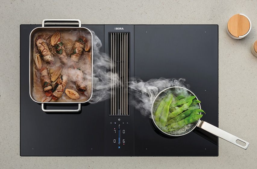 Bora Kochfeld mit Dunstabzug saugt Dampf zwischen Bräter und Topf ab