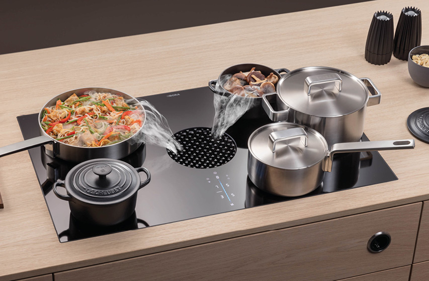 Bora Kochfeld mit Dunstabzug saugt Dampf beim Kochen mehrerer Töpfe ab