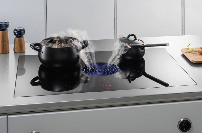 Bora Kochfeld mit Dunstabzug saugt Dampf zwischen zwei Töpfen ab