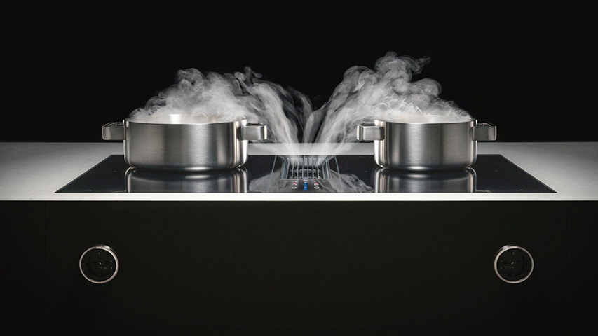 Bora Kochfeld mit Dunstabzug saugt Dampf zwischen zwei Töpfen ab