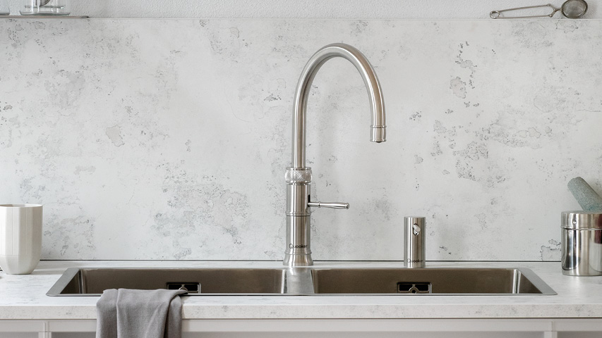 Quooker Wasserhahn über Doppelspüle in moderner Küche, Frontansicht.
