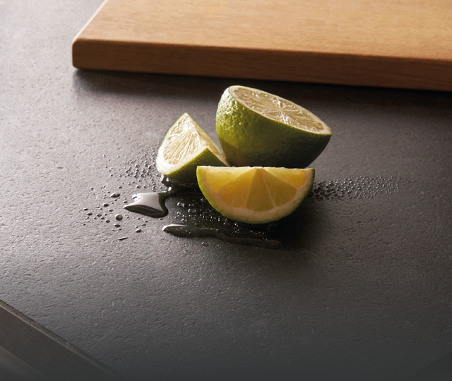 Limettenspalten auf dunkler Küchenarbeitsplatte, Link zu Aktuelles