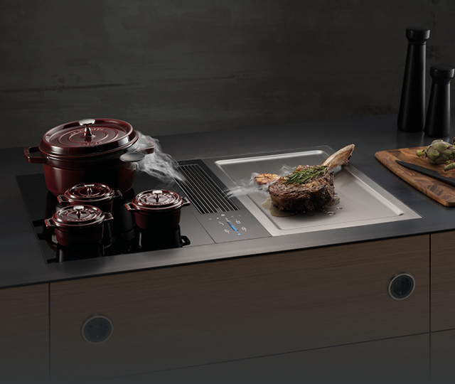 Kochfeld mit integriertem Abzug und dampfenden Töpfen, Link zu Bora Küchengeräte