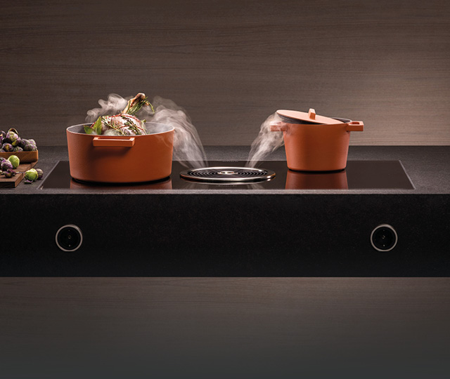 Kochfeld mit integriertem Dunstabzug und dampfenden Töpfen, Link zu Dunstabzüge