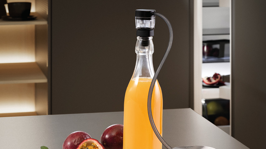 Flasche mit Getränkekühler-Schlauch vor offenem BORA Kühlschrank