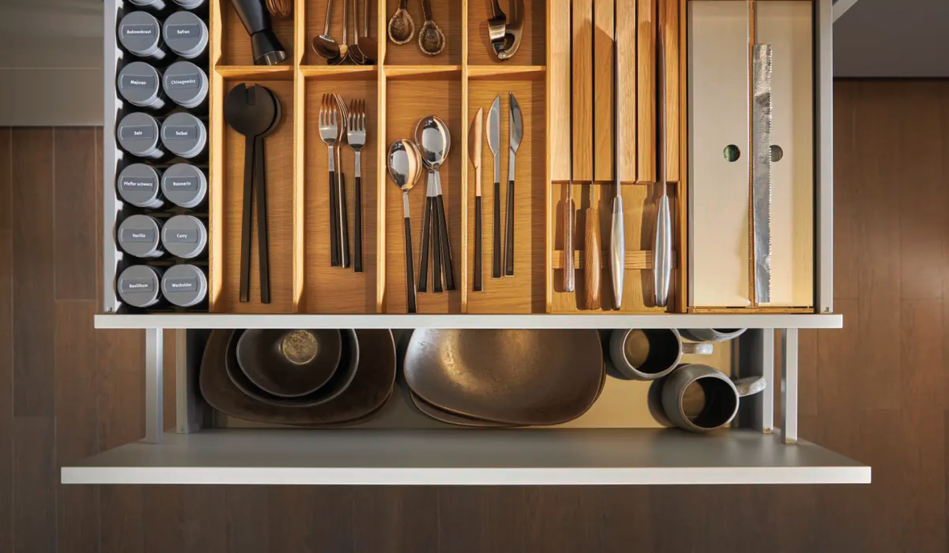 Schubladen-Organisation mit Besteck, Messern und Gewürzen in Holzeinsatz.