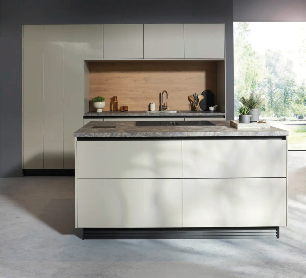 Kochinsel mit hellen Fronten und Spule, moderne Kuche im Hintergrund