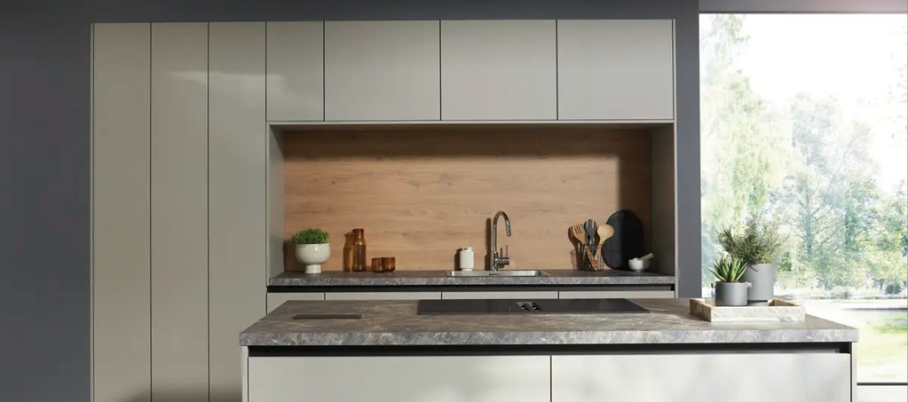 Kochinsel mit hellen Fronten und Spule, moderne Kuche im Hintergrund