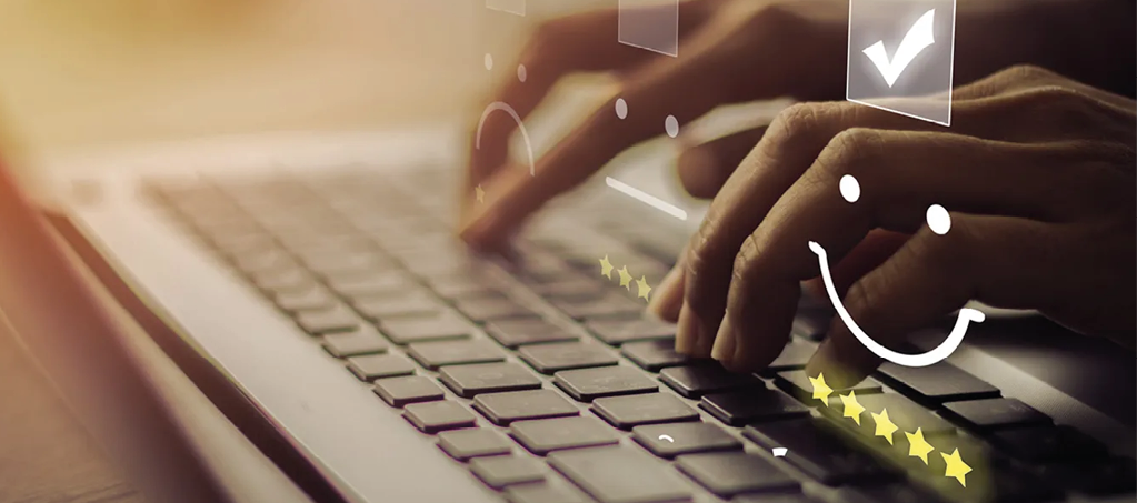 Hände tippen auf Laptop Tastatur während fünf Sterne Bewertung und positive Bewertungssymbole erscheinen. Symbolbild für Kundenzufriedenheit und Online Rezension.