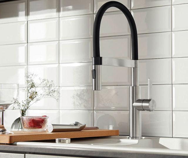 Elegante Küchenarmatur aus Edelstahl vor weißer Fliesenrückwand. Hochwertige Armatur mit modernem Design für Spüle und Arbeitsbereich in der Küche.