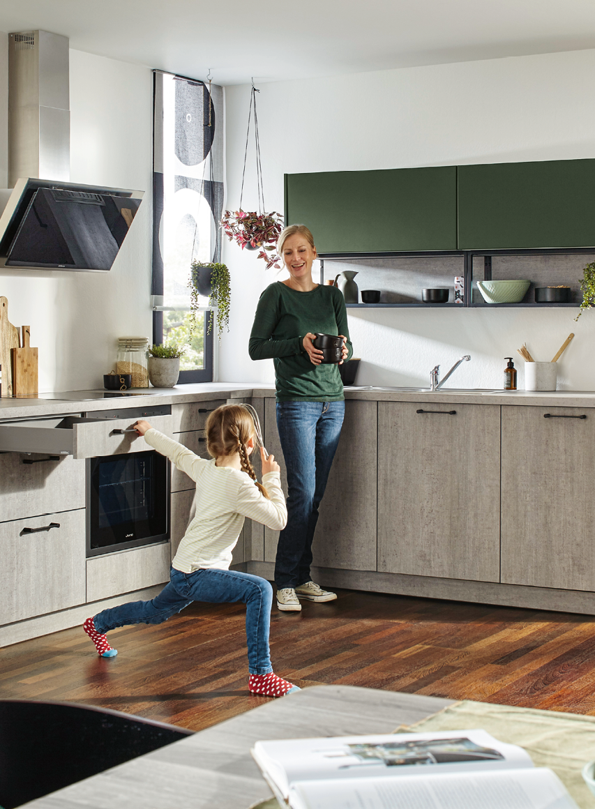 Moderne Familienküche mit Kücheninsel und viel Bewegungsfreiheitx 870_01 Mutter und Kind in einer modernen Familienküche mit Kücheninsel und viel Platz zum Leben während die Küche als Mittelpunkt des Zuhauses genutzt wird