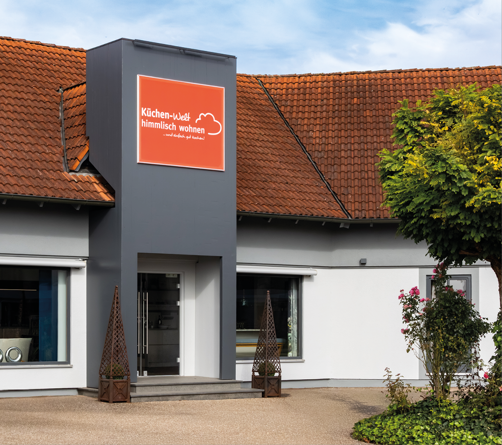 HIM_Filialseite_AB_Grafiken_767 x 680_03 Eingang des Küchenstudios himmlisch wohnen in Asbach Bäumenheim mit moderner Fassadengestaltung und Schaufenstern der Küchen Ausstellung für individuelle Küchenplanung