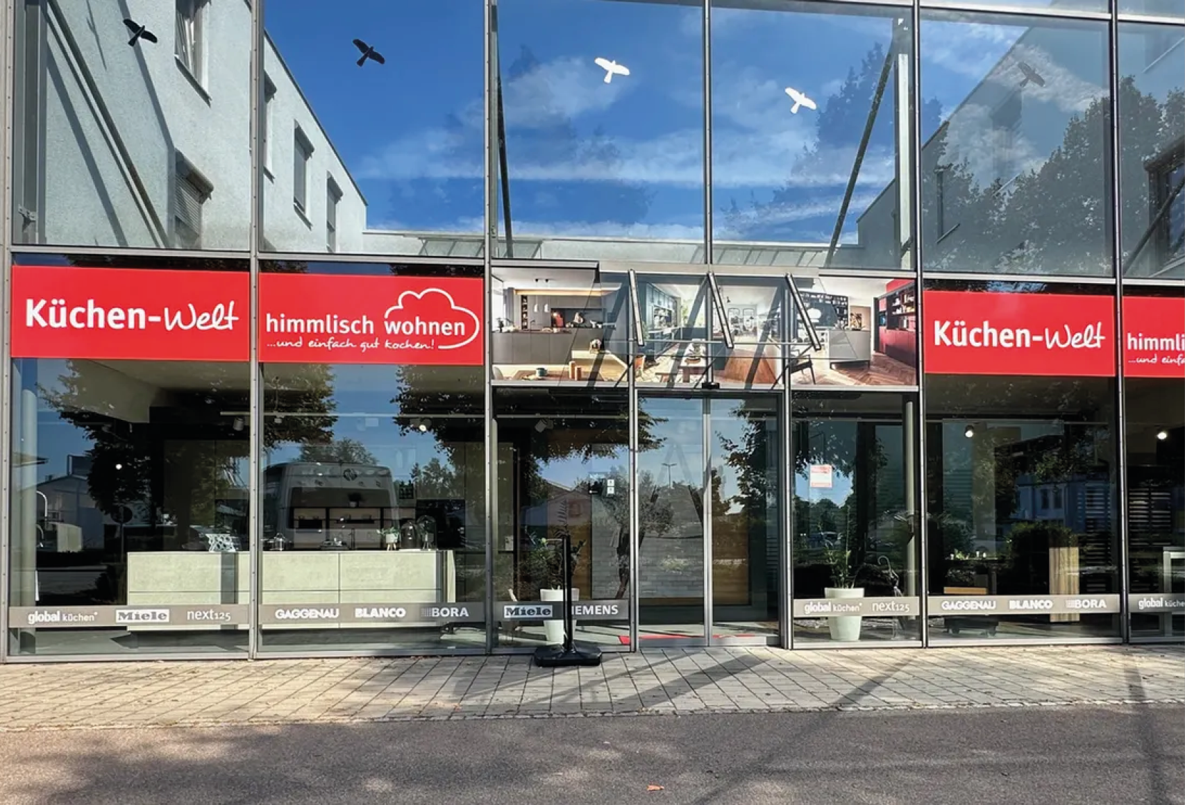 Küchen Welt himmlisch wohnen Aichach Küchenstudio Außenansicht Außenansicht der Küchen Welt himmlisch wohnen in Aichach mit großer Glasfassade und Einblick in die moderne Küchen Ausstellung für individuelle Küchenplanung