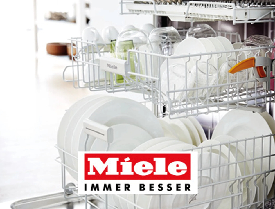 Geöffneter Miele Geschirrspüler mit Geschirrkorb voller Teller und Gläser. Modernes Küchengerät für komfortables Spülen in hochwertigen Einbauküchen.