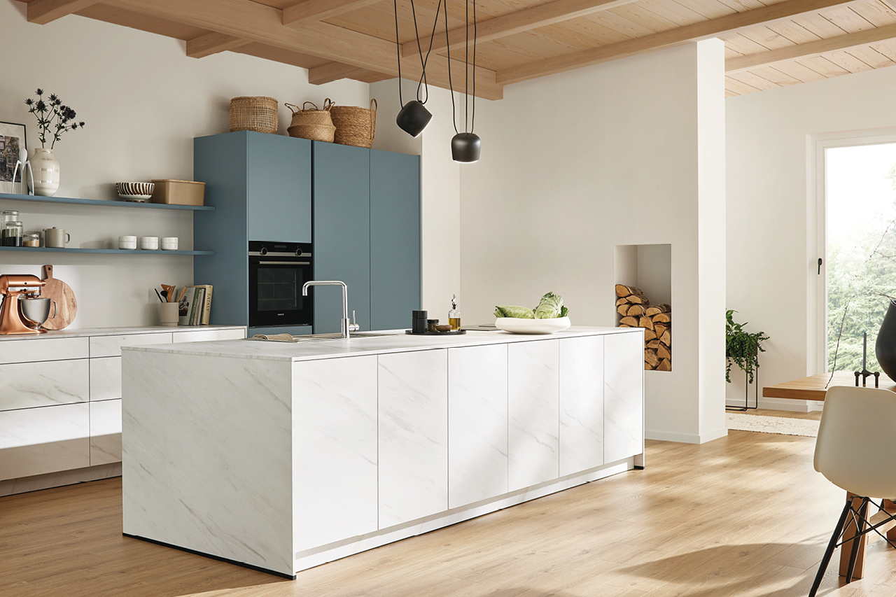 Moderne Wohnküche mit weißer Kücheninsel, blauen Hochschränken und Holzdecke. Stilvolle Einbauküche mit Kochinsel für offene Küchenräume.