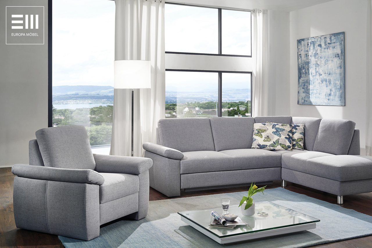 Modernes Wohnzimmer von Europa Möbel mit Ecksofa, Sessel und großem Fenster. Helle Wohnlandschaft mit zeitgemäßem Design und komfortablen Polstermöbeln.