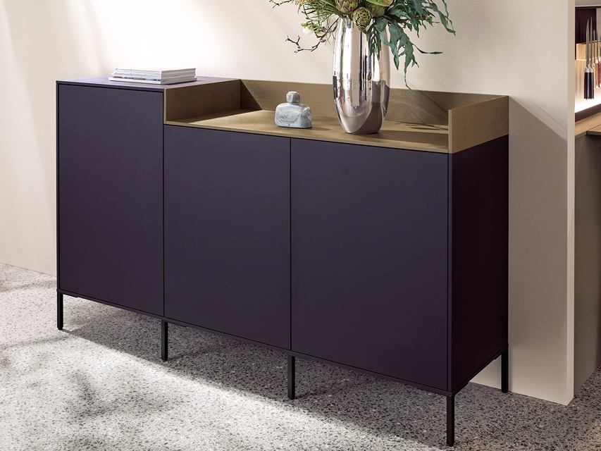 Modernes Sideboard mit matten lila Fronten und Holzoberfläche auf filigranen Metallfüßen. Stilvolles Stauraummöbel passend zur next125 Design Küche.