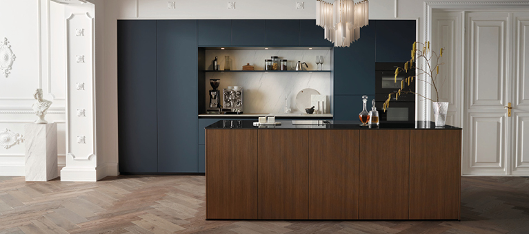 Küche mit dunklen Schränken, Kochinsel mit Holzfront und schwarzer Arbeitsplatte, offene Nische mit Kaffeemaschine und Regalen