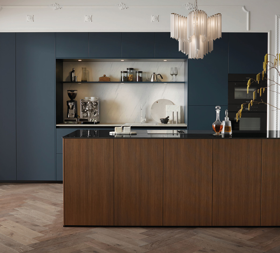 Küche mit dunklen Schränken, Kochinsel mit Holzfront und schwarzer Arbeitsplatte, offene Nische mit Kaffeemaschine und Regalen